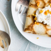 Crepes with orange and cream on brunch plates